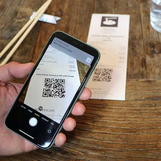 Código QR en un teléfono para pagar con CoinsPay